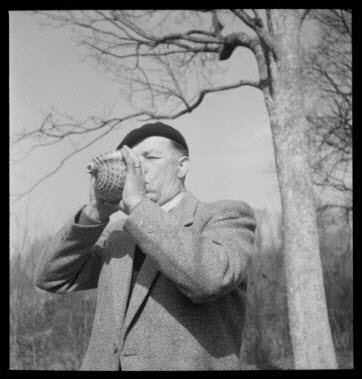 photographie - Domaine de Wideville. Monsieur Ernest Rèbre jouant de la conque pour appeler le cerf. Collection 1954.32.1