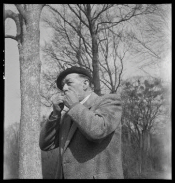 photographie - Domaine de Wideville. Monsieur Ernest Rèbre jouant de la feuille de lierre qui est un appeau de chasse pour l'autour