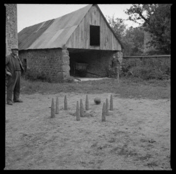 photographie - Vue d'ensemble d'un jeu à neuf quilles dans une cour de ferme